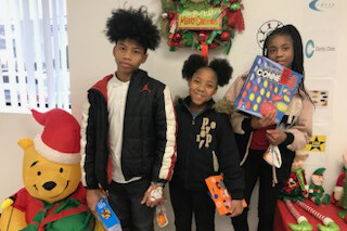 Three children who received gifts during the Universal Toy Drive