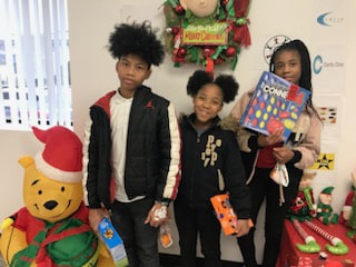 Three children who received gifts during the Universal Toy Drive