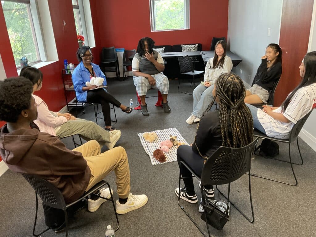 A group of Black and Asian American students sitting in a circle as part of the Racial Healing Collaborative.